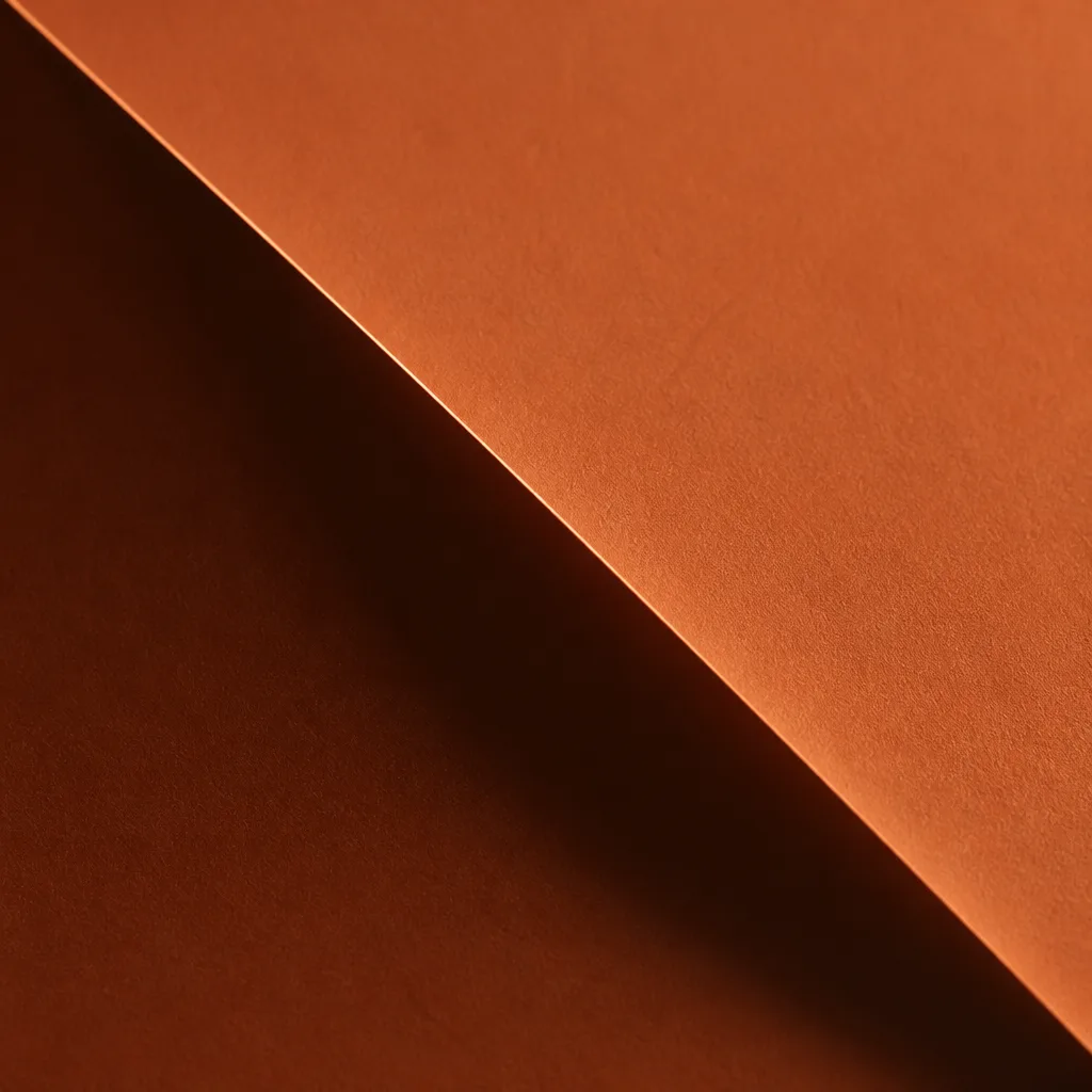 Campo de color terracota mate cortado en diagonal por un pliegue de papel